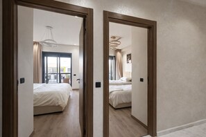 A hotel room with two beds, a balcony, and a view of the city. - 2-bedroom apartment in tranquil Mohammedia with AC comfort (Mohammedia)