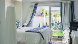 Een slaapkamer met dakraam, een bed met een blauw-witte dekbedovertrek, een nachtkastje en uitzicht op het exterieur.