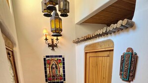 A hallway with a wooden door, a bench with cushions, a stained glass window, and a wall-mounted welcome sign. - Art-Filled South Capitol Retreat \ Walkable \ Private Patios & Deck \ AC (Santa Fe)