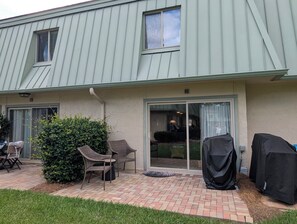 A building with a patio area, outdoor seating, and covered barbecue equipment. - Beach/Pool Access-Location Location Location! (Hilton Head Island)