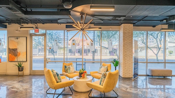 Eine moderne Lobby mit einer zentralen Sitzgruppe, großen Fenstern und Blick auf die Straße.
