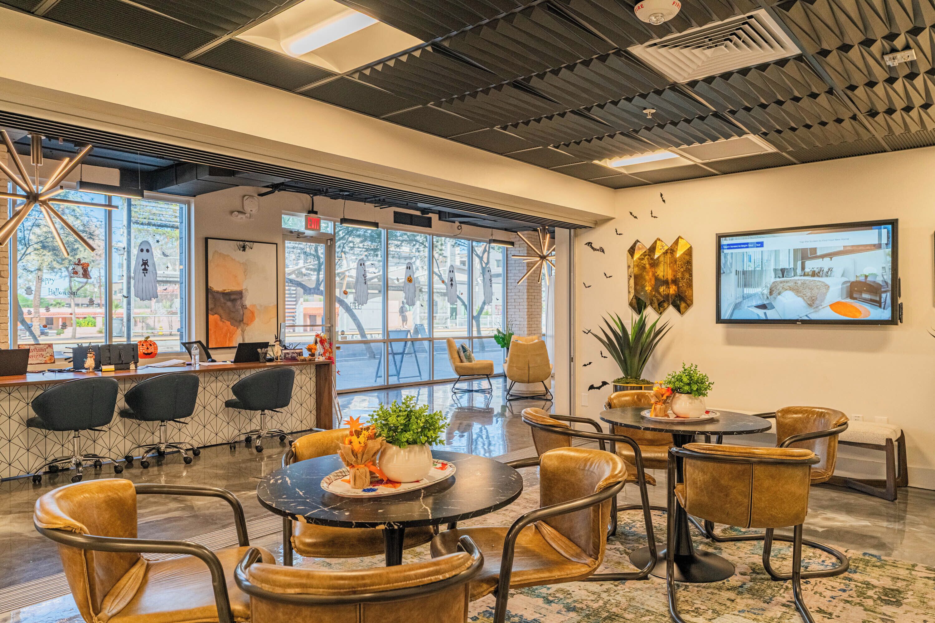 A modern interior with a reception area, seating arrangements, and a large window providing a view of the outdoors.