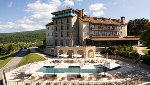 Un grand hôtel doté d’une piscine, d’un espace extérieur aménagé et offrant une vue sur le paysage environnant.