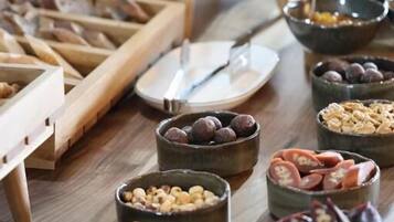 Una mesa de buffet con distintos alimentos y un panecillo.