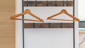 A room with a wooden bench, a blue towel, and a metal rack with wooden hangers. - Charming, light-filled studio - Centre-ville-Gare (Cambrai)