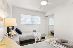 A bedroom with a bed, bedside table, lamp, and a large mirror. - 3BR Home Ideal for Work Trips, Family & Long Stays (Fremont)