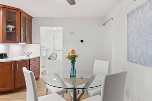 A modern kitchen with wooden cabinets, a glass dining table, and white chairs. - 3BR Home Ideal for Work Trips, Family & Long Stays (Fremont)