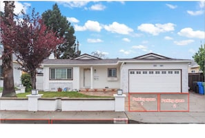 A single-story house with a garage, a driveway, and a tree with red leaves. - 3BR Home Ideal for Work Trips, Family & Long Stays (Fremont)