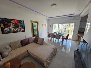 Ein modernes Wohnzimmer mit einem Ecksofa, einem Esstisch und Stühlen.