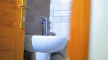 A bathroom with a white sink, a mirror, and a wooden door.