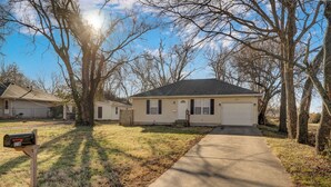 A single-story house with a front yard, a mailbox, and a driveway leading to a garage. - Belmont Blue Stylish Retreat - Bass Pro+MSU+Downtown+Drury (Springfield)