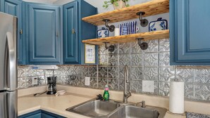 A kitchen with blue cabinets, a stainless steel sink, and a coffee maker. - Belmont Blue Stylish Retreat - Bass Pro+MSU+Downtown+Drury (Springfield)
