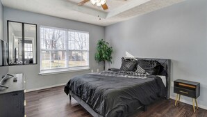 A bedroom with a bed, a nightstand, a dresser, and a ceiling fan. - Belmont Blue Stylish Retreat - Bass Pro+MSU+Downtown+Drury (Springfield)