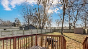 A wooden deck with a grill, a fenced yard, and a shed. - Belmont Blue Stylish Retreat - Bass Pro+MSU+Downtown+Drury (Springfield)