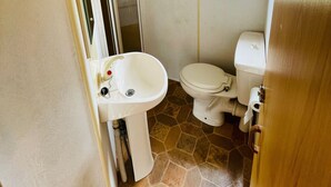 A compact bathroom with a toilet, sink, and a window with a green blind. - A little corner of paradise (Église-Neuve-de-Vergt)