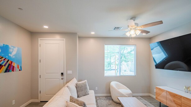A modern living room with a sofa, coffee table, and TV. - The One 313 (Glendale)