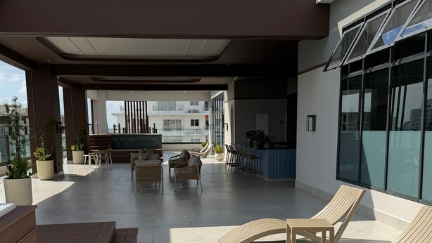 Un espace extérieur aménagé en terrasse, avec des chaises longues, un banc en bois et des plantes en pot.