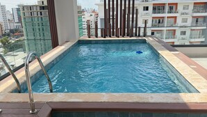 Une piscine sur le toit offrant une vue sur les bâtiments environnants.