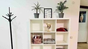 A white shelving unit with various items including a red bag, a decorative moose head, and two potted plants. - Spacious 3BR Apt • 110sqm • Carol Park • Balcony (București)