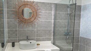 Un bagno moderno con lavabo, specchio e doccia.