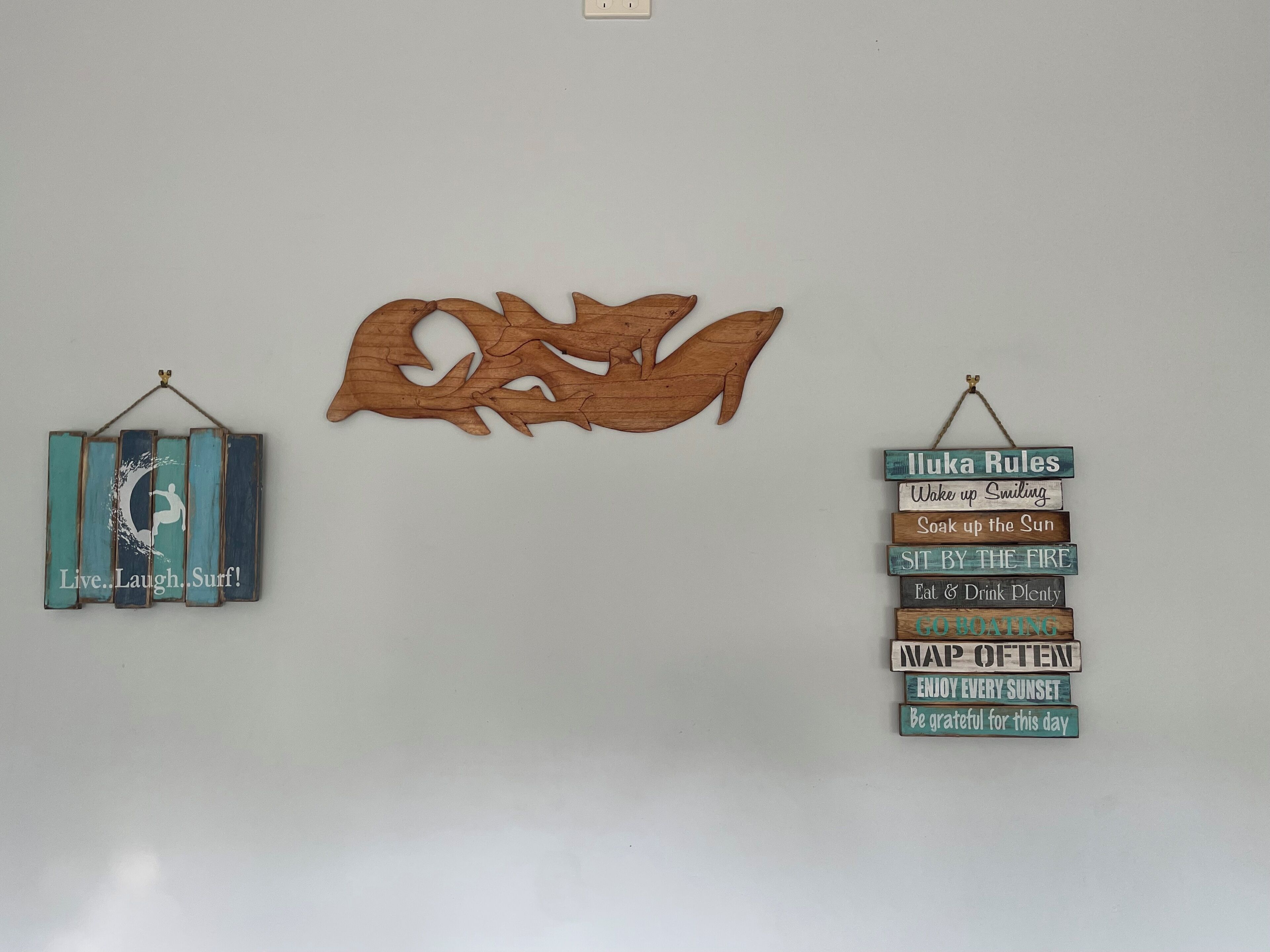 Eine Wand mit einem Holz-Wellenmuster und zwei Schildern mit motivierenden Sprüchen.