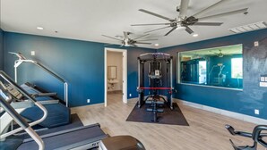 A gym with treadmills, a weight machine, and ceiling fans. - The One 314 (Glendale)