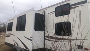 Two RVs with "North Country Lakeside" branding, featuring multiple windows and a simple, utilitarian design. - Cozy 1-bedroom camper sleeps up to 4 
Daily/ weekly / monthly rate’s available (Kingfisher)