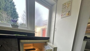 A kitchen with a built-in refrigerator, a window, and a tiled floor. - Long Contractor Stays - HS2 NEC BHX Parking Wifi Netflix Discounts Offered (Birmingham)