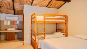 Une chambre avec des lits superposés, un lavabo et un miroir.