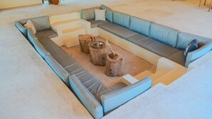 Un canapé modulable aux tons bleu clair et gris, une table basse et deux tabourets en bois.