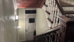A wooden staircase with a white door at the top.