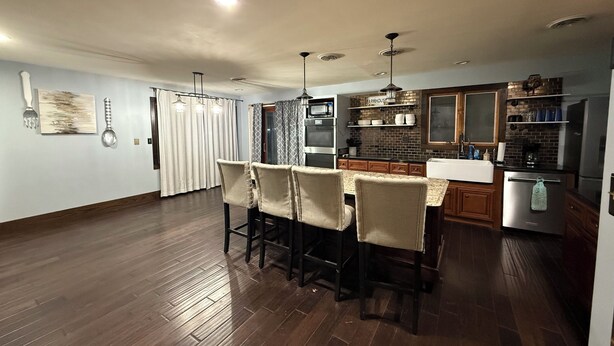 Une cuisine moderne avec un coin repas, un plancher en bois et une décoration de style champêtre.