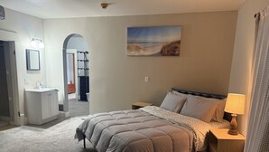 Une chambre à coucher avec un lit, une table de chevet, une lampe et un tableau au mur.