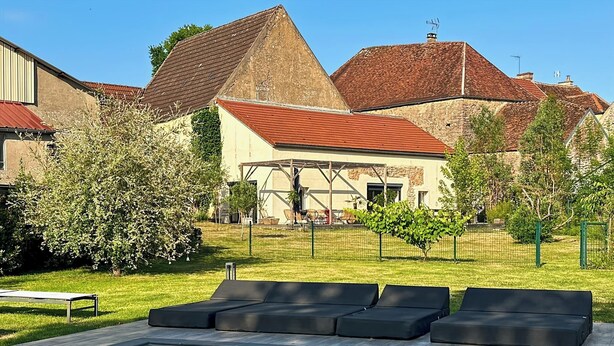A pool area with lounge chairs, a covered seating area, and a building with a red roof and stone walls. - Gîte with swimming pool at the gateway to the Morvan - Up to 15 people (cussy les forges)