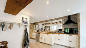 A modern kitchen with white cabinets, a wooden countertop, and a black range hood. - Gîte with swimming pool at the gateway to the Morvan - Up to 15 people (cussy les forges)