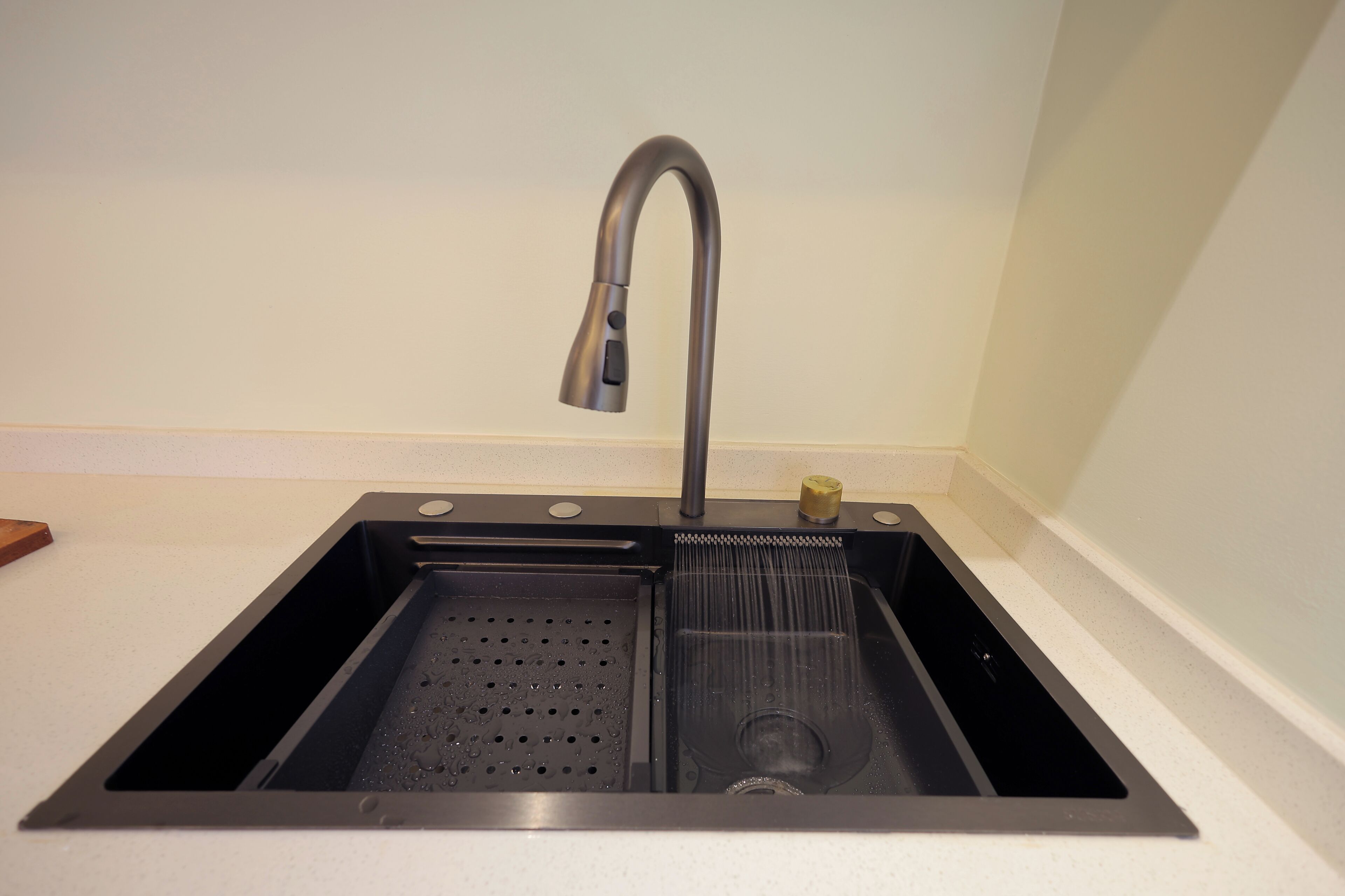 Un moderno lavamanos de cocina con un solo grifo, un lavabo de acero inoxidable y un colador incorporado.