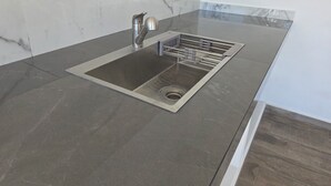 A modern kitchen with a stainless steel sink, a built-in drying rack, and a marble backsplash. - Weekend or vacation home, with pool and large garden. (Tlayecac)