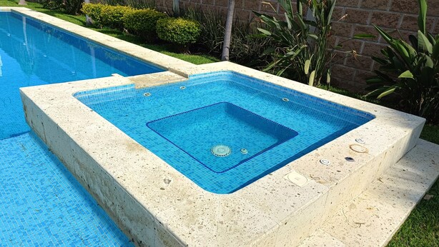 A rectangular swimming pool with a tiled deck area and a small hot tub. - Weekend or vacation home, with pool and large garden. (Tlayecac)