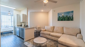 A modern living room with a beige sofa, a marble coffee table, and a ceiling fan. - Access 3011 (Tempe)