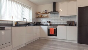 Eine moderne Küche mit weißen Schränken, einem schwarzen Backofen und einem schwarzen Kühlschrank.