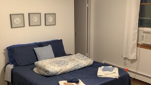 Un dormitorio con cama, ventilador de techo y ventana con cortinas.