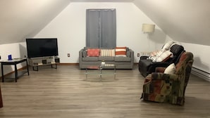Un salón estilo loft con televisor, sofá y sillón.