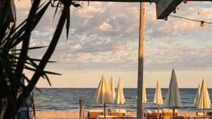 Une promenade en bois mène aux parasols et aux chaises longues de la plage.
