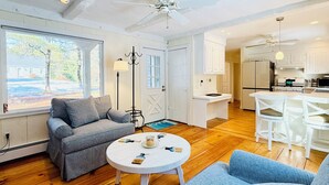 Ein modernes Wohnzimmer mit einer Couch, einem Couchtisch und Blick ins Freie.