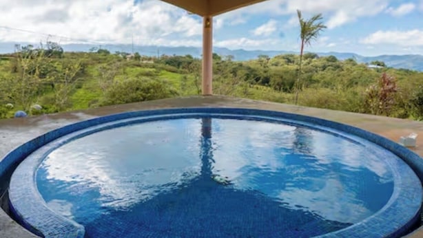 Une piscine circulaire offrant une vue dégagée sur un paysage montagneux.