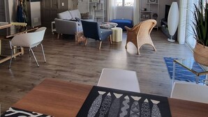 En rummelig stue med sofa, lænestole, sofabord og et gulvtæppe.