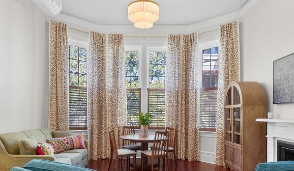 A cozy living room with a round table, a sofa, and a fireplace.