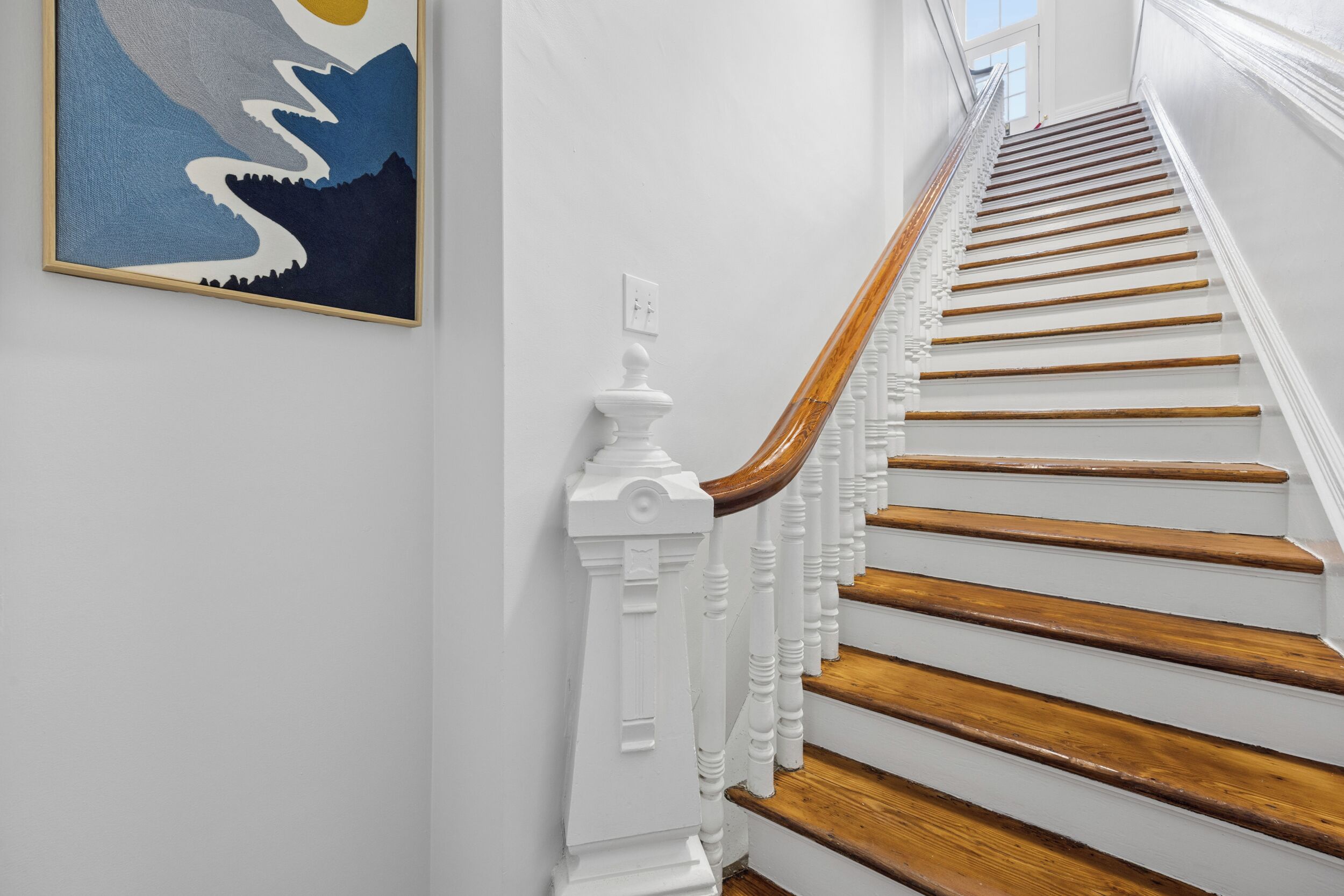 A staircase with white balusters and wooden steps.