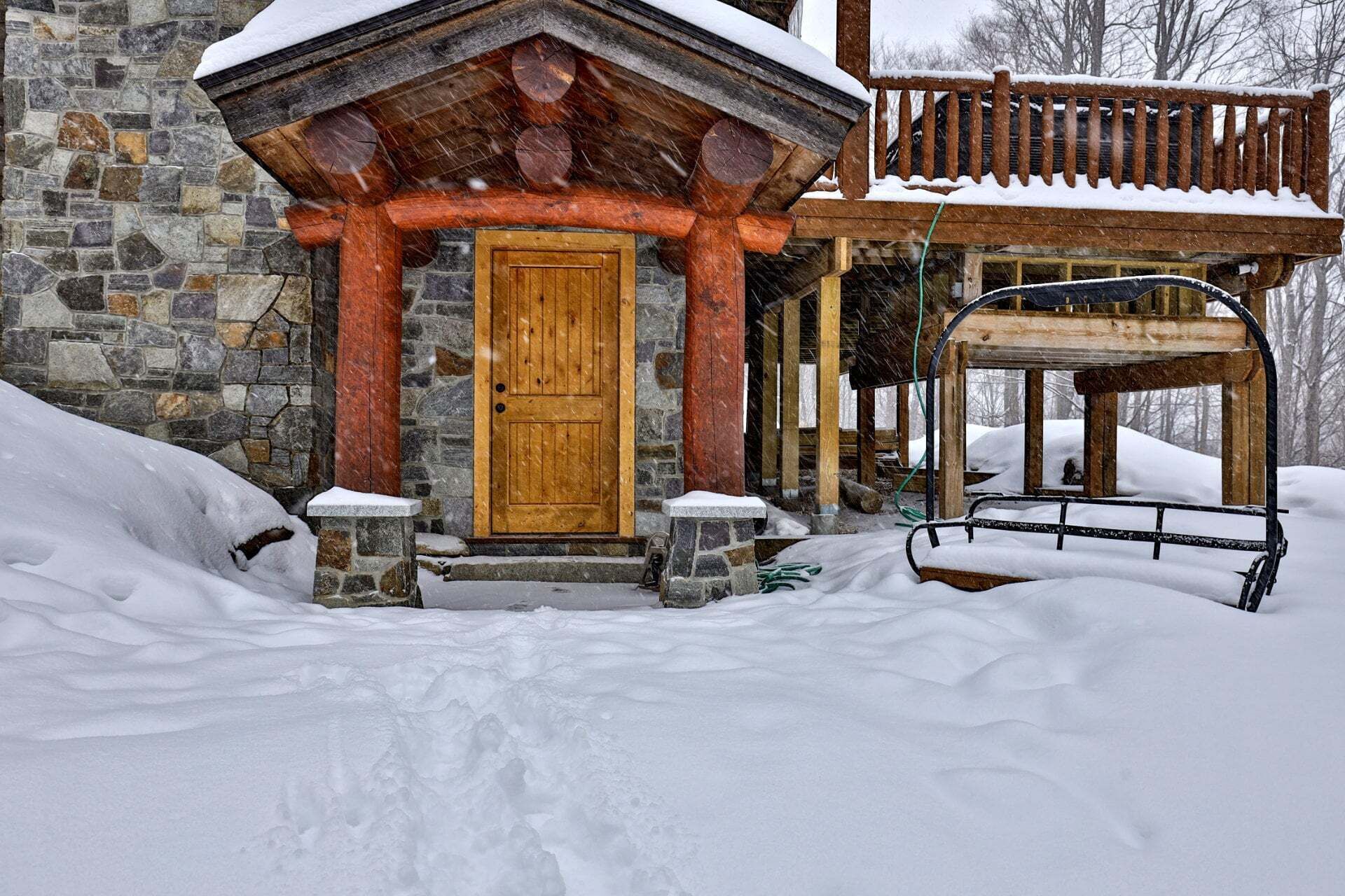 The covered side entry gives guests a sheltered route into the cabin on snowy days.