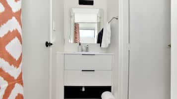 A bathroom with a white sink, mirror, and towel rack.